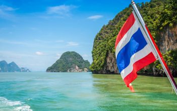 Tourist using crypto wallet in Thailand with temples in background