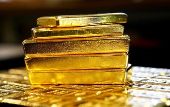 Gold bars with declining price chart reflecting market trends