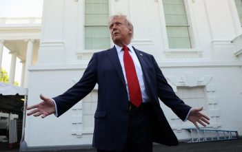 Donald Trump speaking with U.S. financial markets in the background