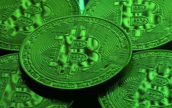 Bitcoin symbol with declining graph indicating price drop