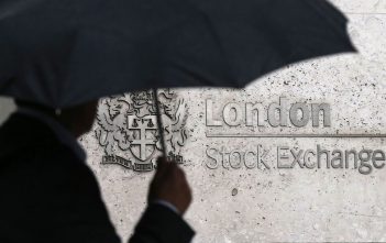 FTSE 100 stock chart with upward arrow, UK inflation and pound symbols