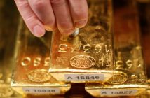 Gold bars and coins with upward trend graph indicating price rebound
