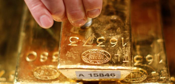 Gold bars and coins with upward trend graph indicating price rebound