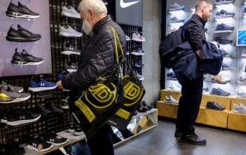Logos of JD Sports, Adidas, and Puma with upward-trending stock charts