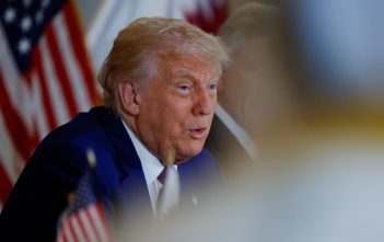 Donald Trump speaking with Iranian and Israeli flags in the background